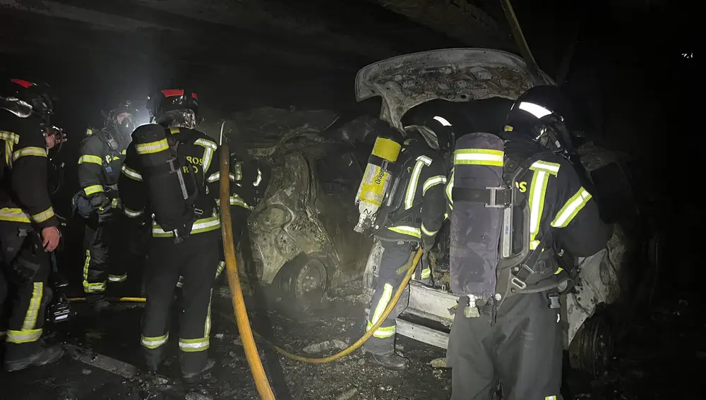 Les pompiers à côté des véhicules brûlants