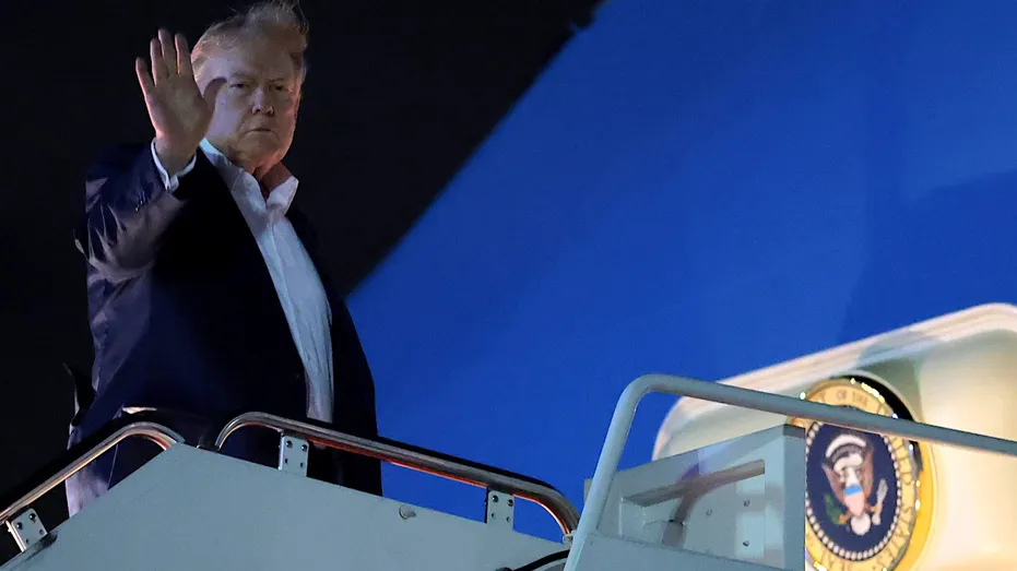 le président Donald Trump salue avant d'entrer dans Air Force One