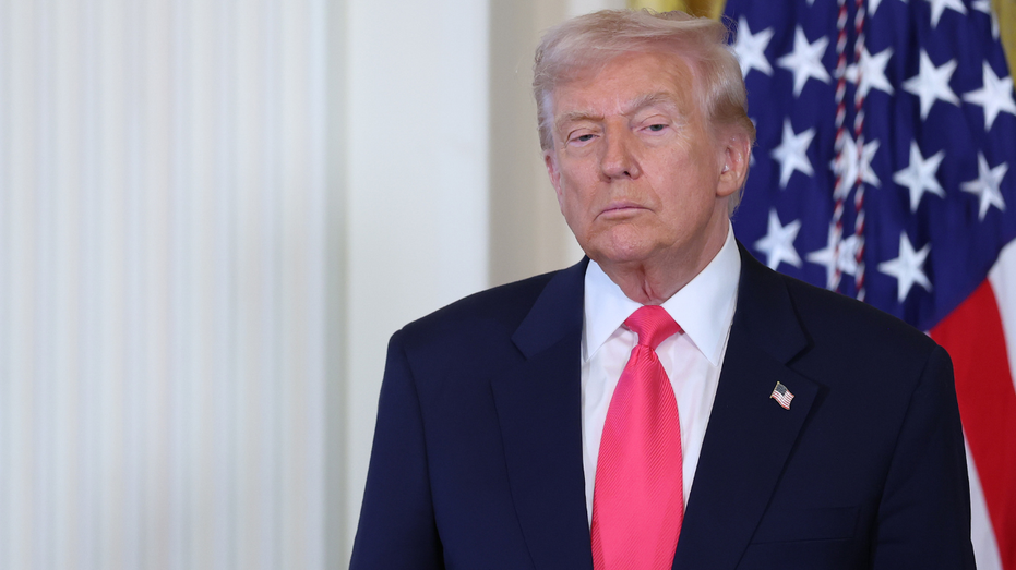 Le président Donald Trump se tient devant un drapeau américain à la Maison Blanche.