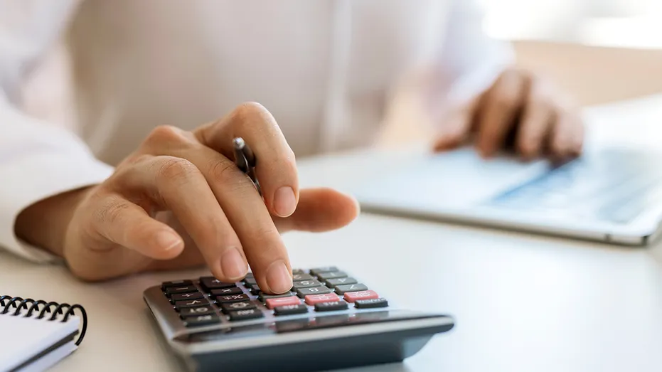 Homme d'affaires méconnaissable calculant et planifiant au bureau