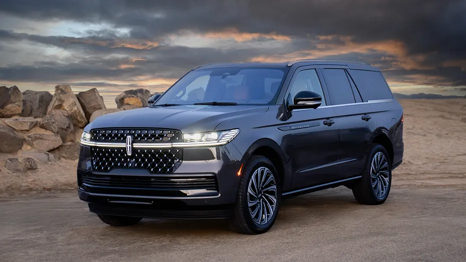 Un SUV Lincoln Navigator est exposé sur fond de désert au coucher du soleil.