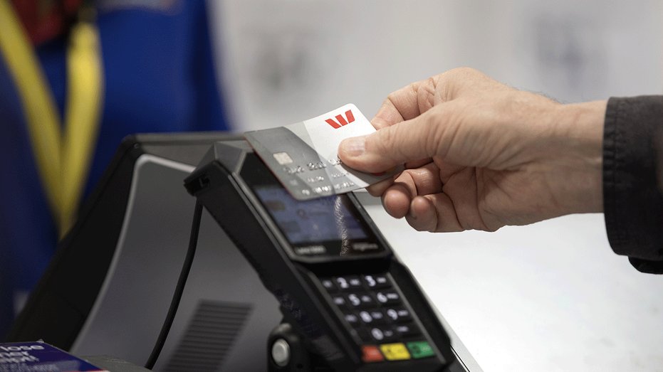Personne tapant une carte de crédit sur un lecteur