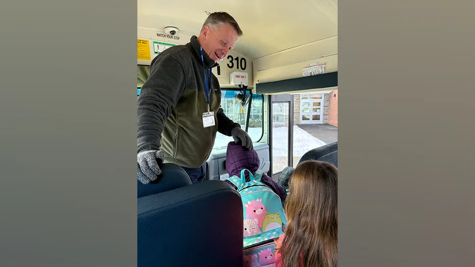 Kurtis Kotes aide les élèves à monter à bord d'un autobus scolaire lors d'un trajet matinal.