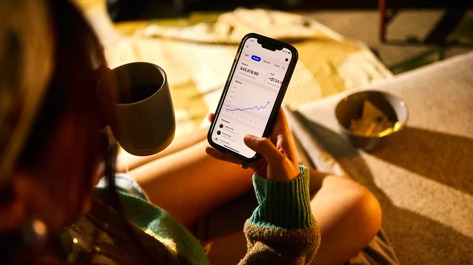 Une personne vérifie la performance d'un portefeuille d'investissement sur un smartphone.