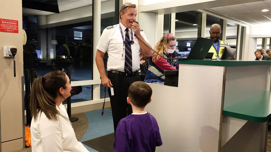Un employé d'Avelo Airlines s'adresse aux passagers à une porte d'embarquement avant un vol.