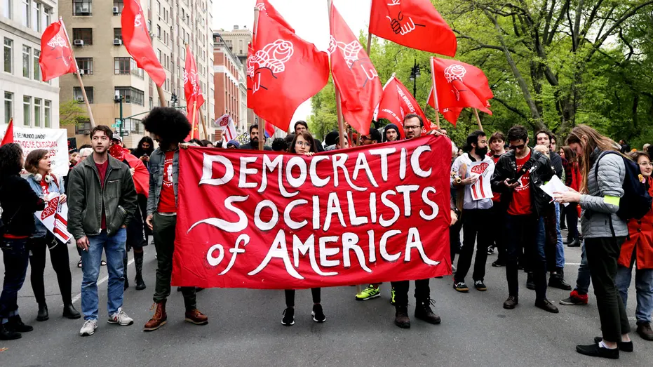 Les gens tiennent une pancarte des Socialistes démocrates d’Amérique.