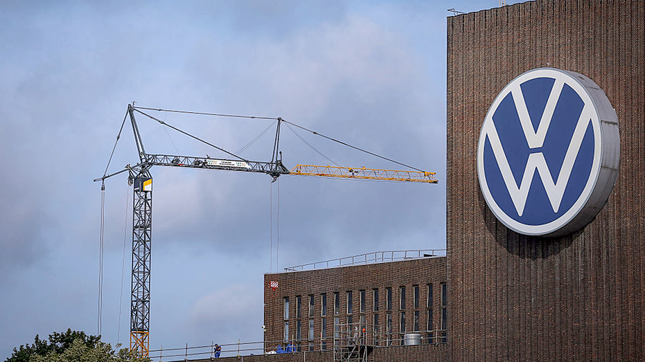Une grue de chantier se trouve à côté du logo VW
