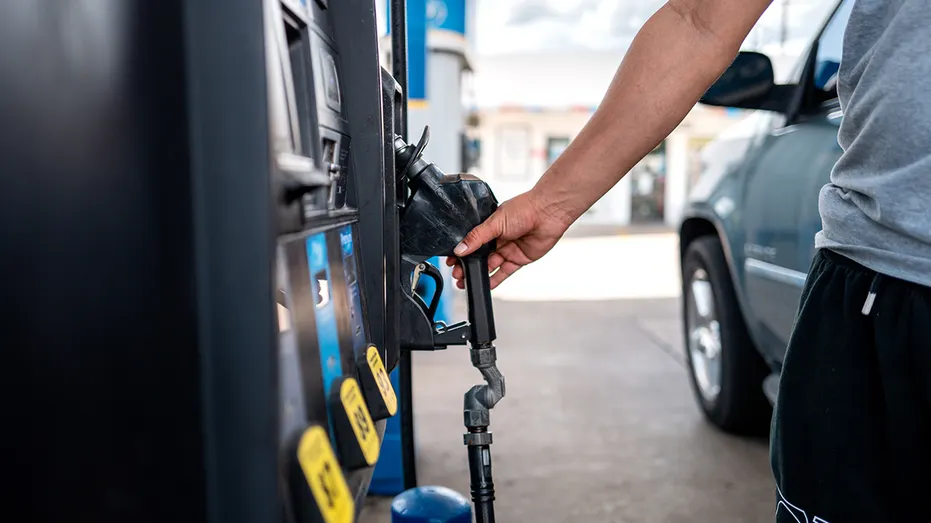 La main d'une personne tire pour la pompe d'une station-service