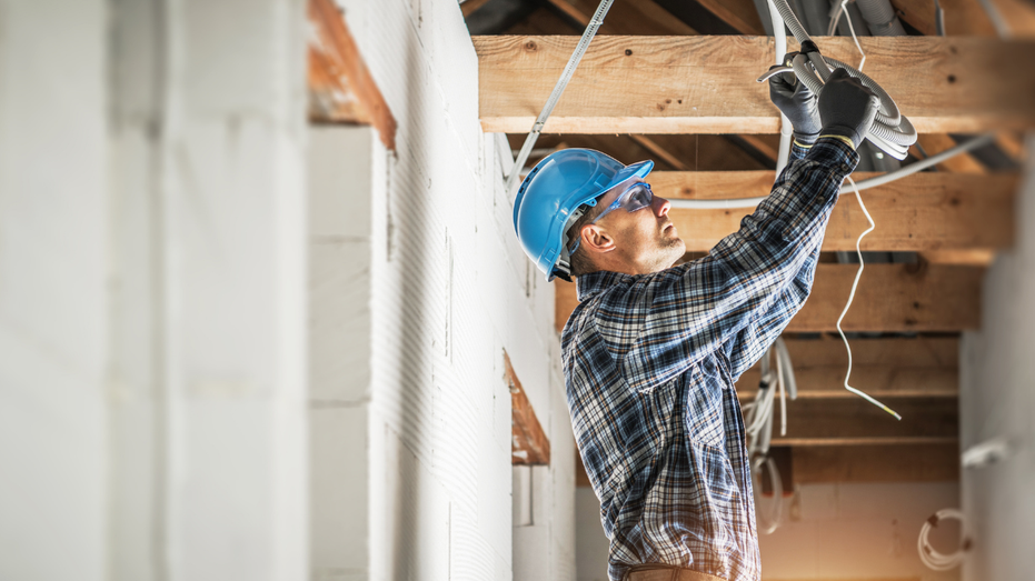 Un électricien travaillant dans une nouvelle maison
