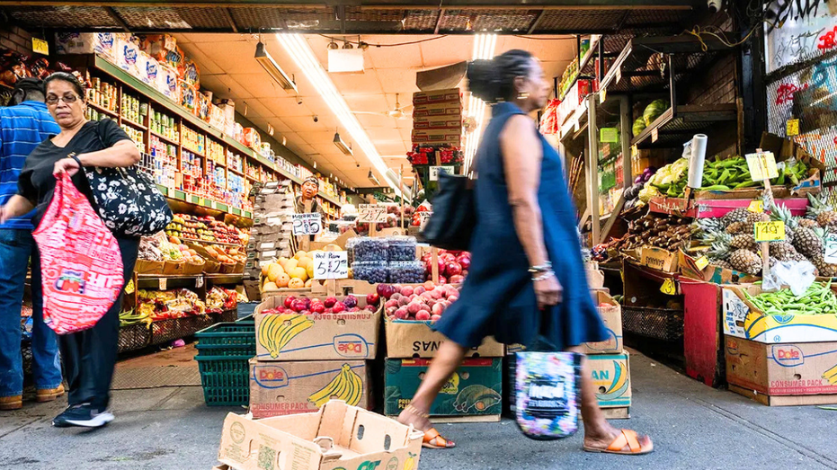 On voit une femme marcher près d’une bodega à New York.
