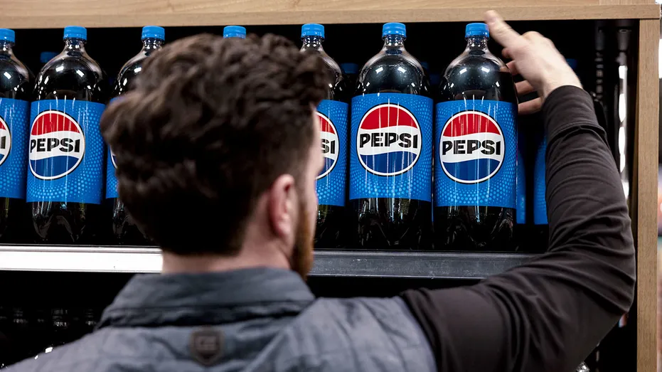 Un ouvrier dépose des bouteilles de Pepsi sur une étagère.