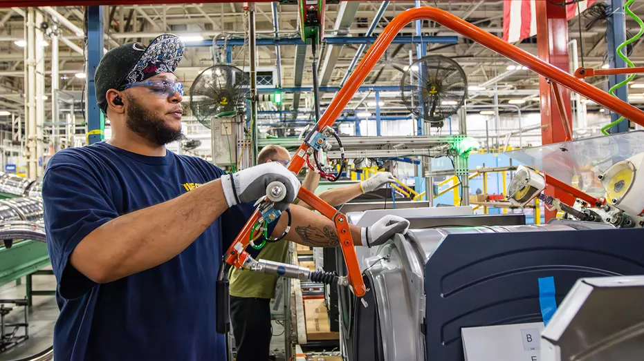 Un employé de GE travaillant dans une usine de fabrication