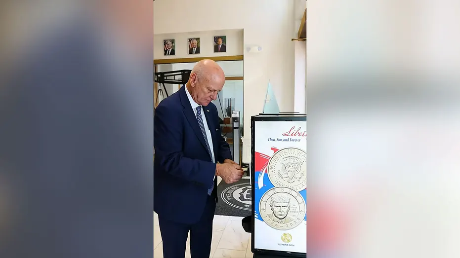Le trésorier américain Brandon Beach se tient à côté d'un présentoir montrant la nouvelle pièce d'un dollar de Trump.