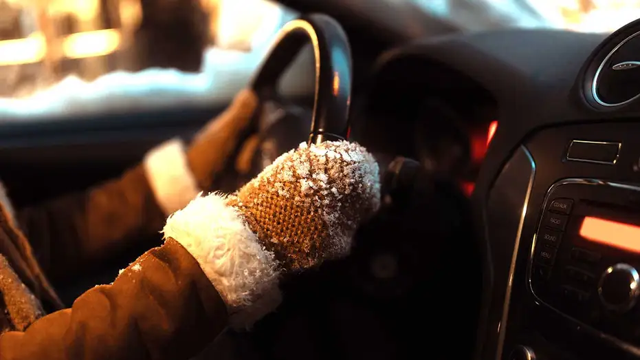 Un conducteur a les mains gantées sur le volant